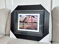 Framed Tom Thomson West Wind print with corner protectors