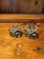 Two crystal salt cellars in sterling holders with spoons, frontal view