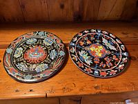 Pair of Bopla! Evolution plates on wood surface, showing full designs