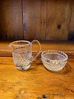 Front view of Waterford Irish Lace creamer and sugar set on wooden surface