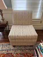 Front view of upholstered armless chair showing fabric pattern and feet