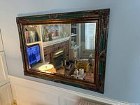 Front view showing full rectangular mirror and ornate green and gold frame