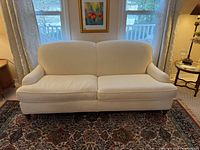 Front view of cream sofa showing overall design and condition