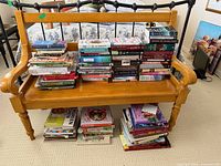 Full view of bench with multiple stacks of books on seat and shelf