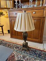 Full view of urn-style lamp with shade in room setting