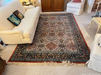 Full view of wool multicolour area rug placed between sofa and chairs