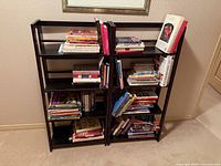 Front view of both black shelving units filled with books
