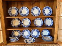 Entire lot of flow blue plates and bowls displayed in cabinet