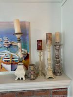 All five wood candlestick holders on shelf, showing varied sizes and finishes