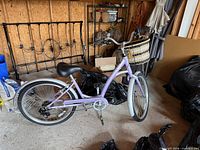 Left side view of the lavender Manhattan Deluxe Smoothie cruiser bike showing frame, wheels, handlebars, basket