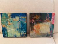 Both framed square paintings on sofa, showing overall size and color contrast