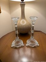 Pair of Ivima clear glass candlesticks on table showing overall design