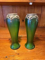 Front view of both green iridescent vases showing metal overlays