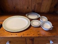All ten pieces displayed: 16-inch platter, smaller oval plate, four soup bowls, four saucers