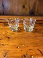 Both crystal glasses side by side on wood surface