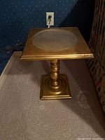 Front view of square gilt gold pedestal side table