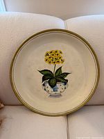 Front view of round metal tray showing floral design and rim