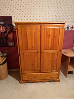 Full front view of pine armoire showing doors, drawer, knobs and overall finish