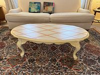 Top view of cream oval coffee table showing lattice pattern and overall condition