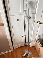 Full view of two chrome rods with brackets and hardware