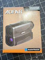 Front of retail box showing AOFAR laser rangefinder image and rainproof marking