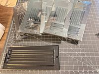 Six packaged registers stacked with one unwrapped register