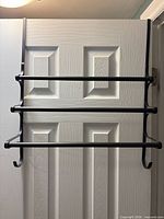 Full view of black metal towel rack hanging on interior door