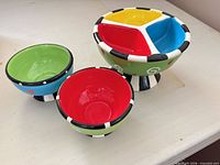 Front view showing large divided bowl and two small bowls, highlighting colors and design