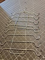 Full view of chrome scarf/tie organizer laid flat showing six tiers and swivel hook