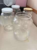 Four large glass jars with various lids