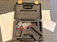 Open CZ pistol case showing foam insert, cleaning rod, brush, manual, warranty card and target sheet