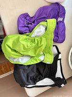 Three diapers in black, purple, green laid out