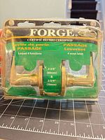 Front view of sealed Forge polished brass passage door lever set on blister card