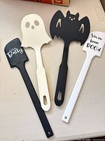 All four plastic Halloween spatulas laid out flat
