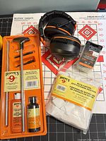 All items: Hoppe's cleaning kit tray, cotton patches bag, bore brush pack, black/orange earmuffs