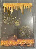 Front of folded card showing gold drip and fireworks design