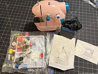 Sewing machine, power adapter, accessories pack in plastic bag, manuals