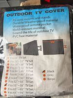 Front of sealed package showing Outdoor TV Cover label, specifications and size chart