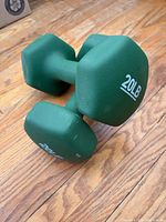 Pair of green 20 lb neoprene-coated dumbbells on wood floor