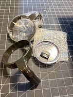 Group view of lid, handle ring, seals and bubble wrap packaging
