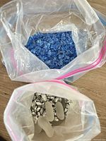 Top-down view of two bags showing blue glass pieces and silver stones with frosted pebbles