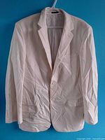 Front view of light beige single-breasted jacket on hanger