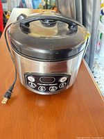 Front view of Hamilton Beach rice cooker showing stainless exterior, control panel and power cord