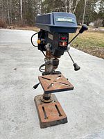 Full view of drill press showing overall structure, table, base and general wear