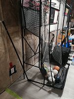 Side view of partially assembled SportCraft triple hoop basketball game frame, netting and several balls in ramp