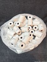 Bag containing many white thermal receipt paper rolls