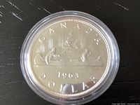 Reverse side of 1963 Canadian silver dollar in capsule