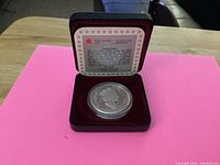 Coin in open red clamshell case with insert visible