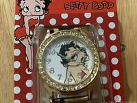 Front view of watch in packaging showing dial design and rhinestone bezel