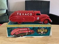 Left side view of red Texaco 1939 Dodge Airflow die-cast truck on top of original box